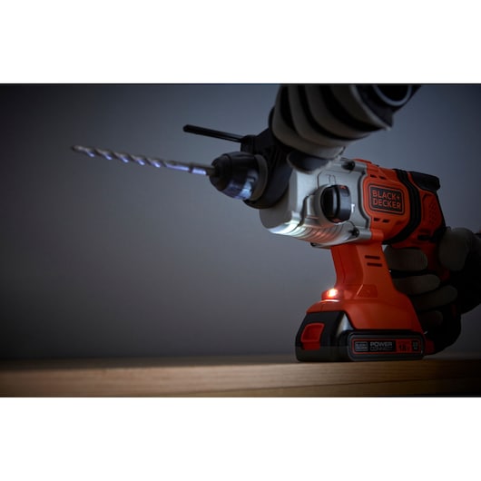 BLACK+DECKER BCD900B hammer drill photography, close-up with drill bit, orange and black body.