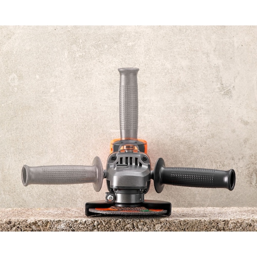 BLACK+DECKER BCG720M1 angle grinder front view on concrete surface, three-position handle, silver and black.