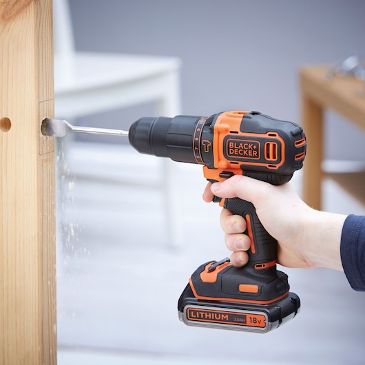 Photo of BLACKDECKER BDCHD18K1B2 cordless drill in use drilling a hole in a wooden beam.