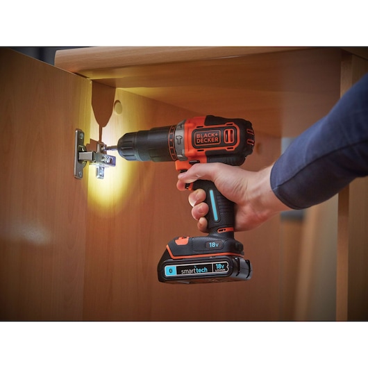 BLACKDECKER BDCHD18KST cordless drill in use assembling wood furniture, features smarttech 18V battery.