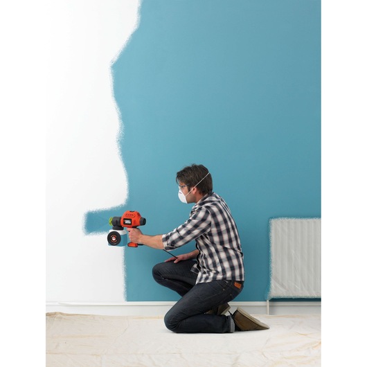 BLACKDECKER BDPS200 paint sprayer used to apply blue paint to a wall, product in action.