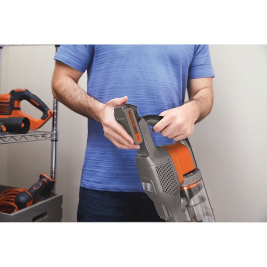 Photo of BLACKDECKER BHFEV182B cordless vacuum cleaner with person inserting 18V battery.