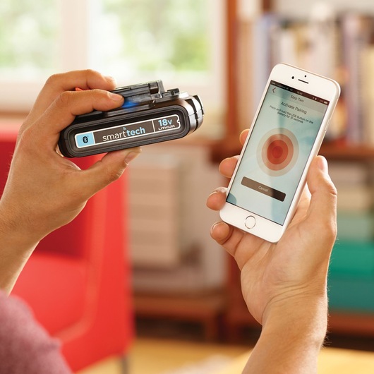 Photo of BLACKDECKER BL1518ST smarttech 18V lithium battery being paired with smartphone in hand.