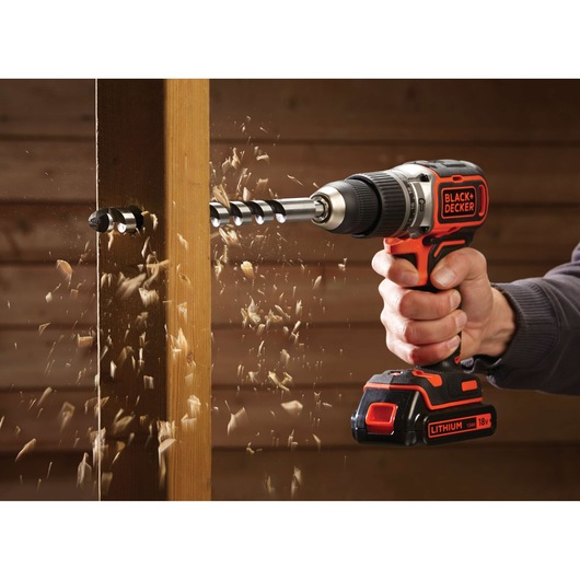 BLACKDECKER BL188K cordless drill in use, drilling through wood, photography of sawdust flying.