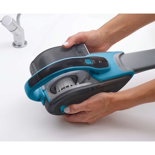BLACKDECKER DVJ320J handheld vacuum photography, blue and gray, shown being opened by hand.
