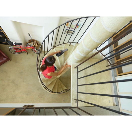 BLACKDECKER DVJ325BF handheld vacuum used to clean spiral staircase in modern home, top view photography.