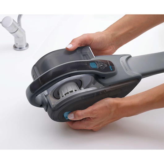 Photo of BLACKDECKER DVJ325BF handheld vacuum cleaner detail, shown in use on a white surface.