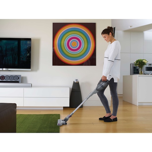 BLACKDECKER FEJ520JFS cordless vacuum used on green rug in modern living room.