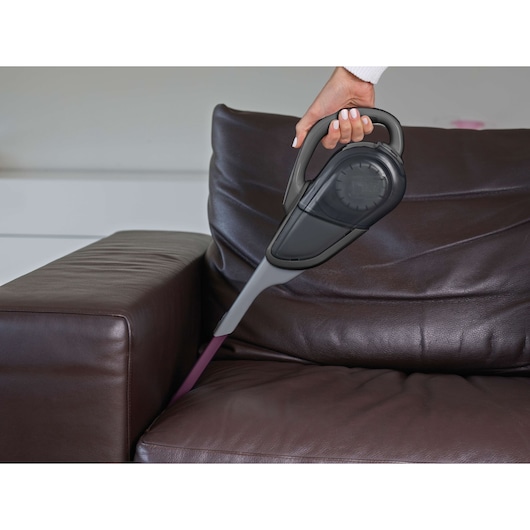 BLACKDECKER FEJ520JFS handheld vacuum cleaning between sofa cushions indoors.