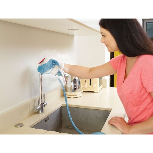 BLACKDECKER FSMH1351SM steam cleaner used on kitchen faucet, countertop setting.
