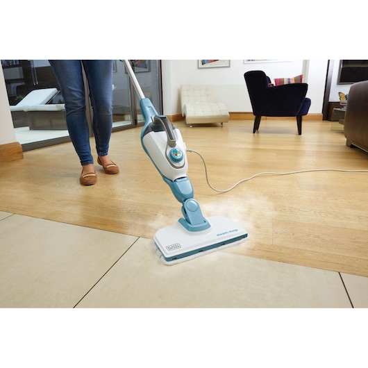 BLACKDECKER FSMH1351SM steam mop in white and blue cleaning tile and wood floor in a modern living room.