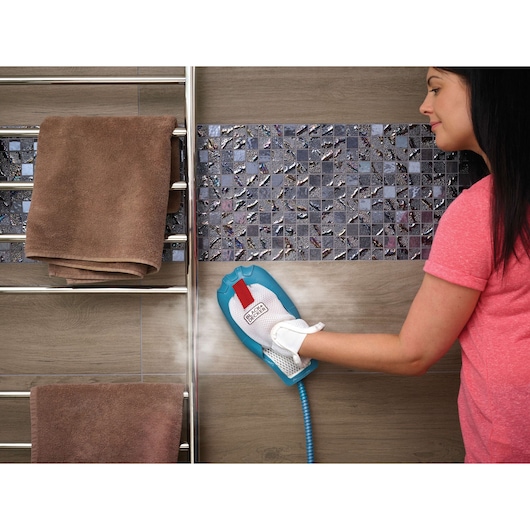 BLACK+DECKER FSMH1351SM steam cleaning glove cleaning wall tiles, hand in white cleaning glove.