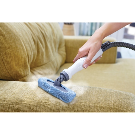 Photo of BLACKDECKER FSMH1351SM steam cleaner with hose and blue cloth cleaning a yellow sofa.