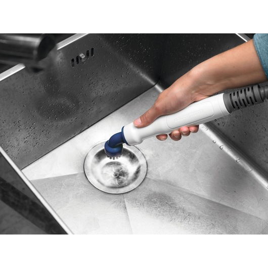 Photo of BLACK+DECKER FSMHKA handheld cleaning tool cleaning a stainless steel sink drain.