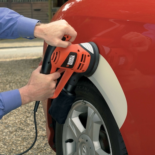 Photo of BLACKDECKER KA191EK sander polishing red car fender, handheld, corded, close-up.