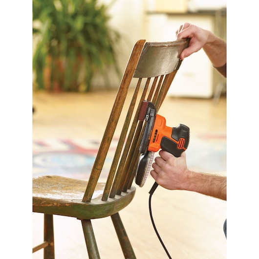 BLACKDECKER KA2000 electric sander used to sand wooden chair spindles indoors.