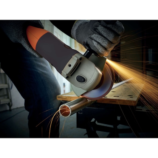 BLACKDECKER KG1202K angle grinder cutting metal pipe, sparks flying, photography close-up.