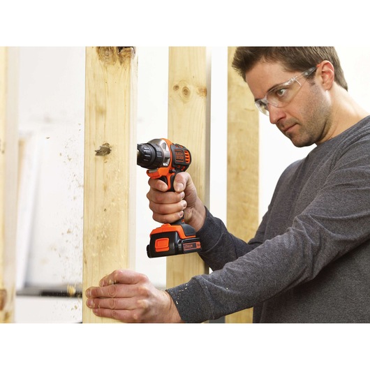 Photo of BLACKDECKER MT218KB cordless drill in use drilling through vertical wooden beams.