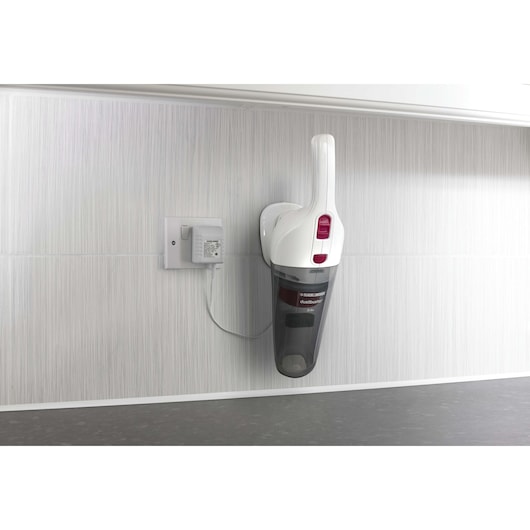 BLACKDECKER NV3610N handheld vacuum in white and black, wall-mounted and charging, side angle.