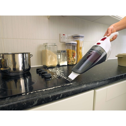 BLACKDECKER NV3620N handheld vacuum cleaning rice on kitchen counter, side angle.