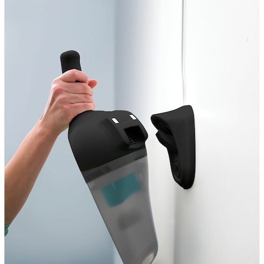 Photo of BLACKDECKER NV7210N handheld vacuum cleaner being placed on wall-mounted charging station.