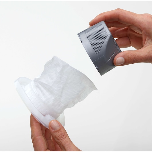 Two hands are holding parts of a vacuum cleaner filter assembly. One hand is holding a grey cylindrical filter cover, and the other hand is holding a white filter element attached to a plastic ring. The parts are separated, showing how the filter can be removed or changed.