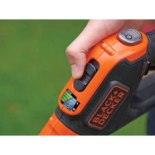 Photo of BLACK+DECKER STC1820EPC detail, close-up of thumb on control switch with power mode indicator.