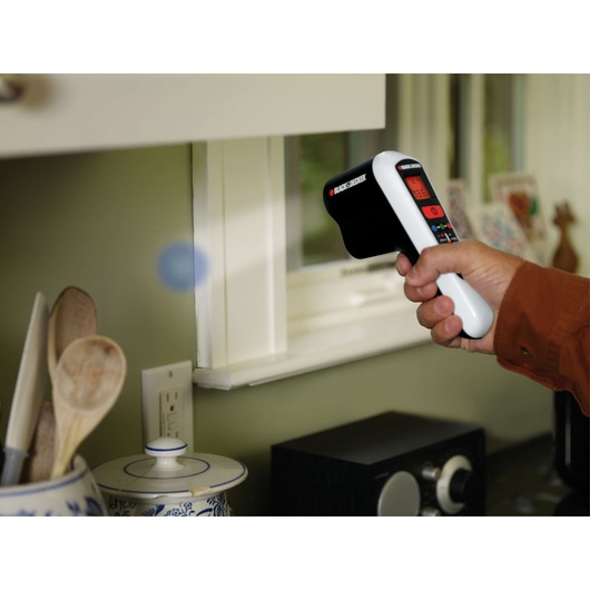 BLACKDECKER TLD100 thermal leak detector used near a window in a kitchen setting.