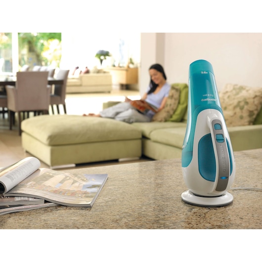 BLACKDECKER WD9610N handheld vacuum on charging base in modern living room, magazine in foreground.