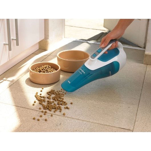 BLACKDECKER WD9610N handheld vacuum cleaning pet food on kitchen floor, bowls in background, product photography.