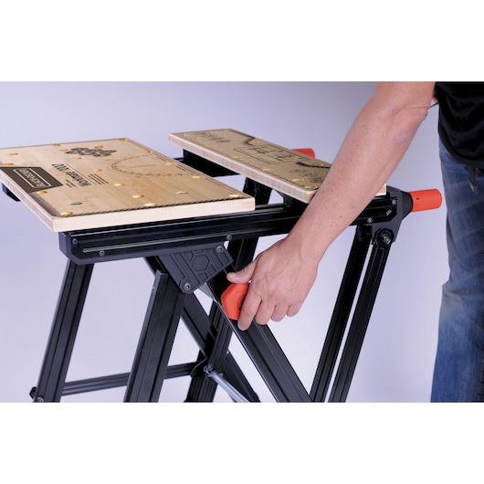 BLACKDECKER WM1000 workbench, side angle, wood surface with printed measurements and orange adjustment knob.