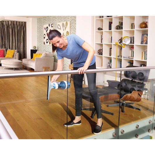 BLACKDECKER WW100 window vacuum cleaning glass railing in modern living room.
