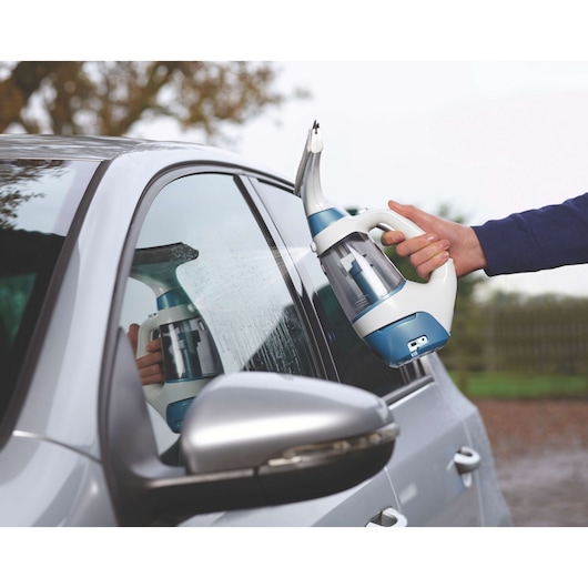 BLACKDECKER WW100 window vacuum cleaner used on car window, handheld, blue and white design.